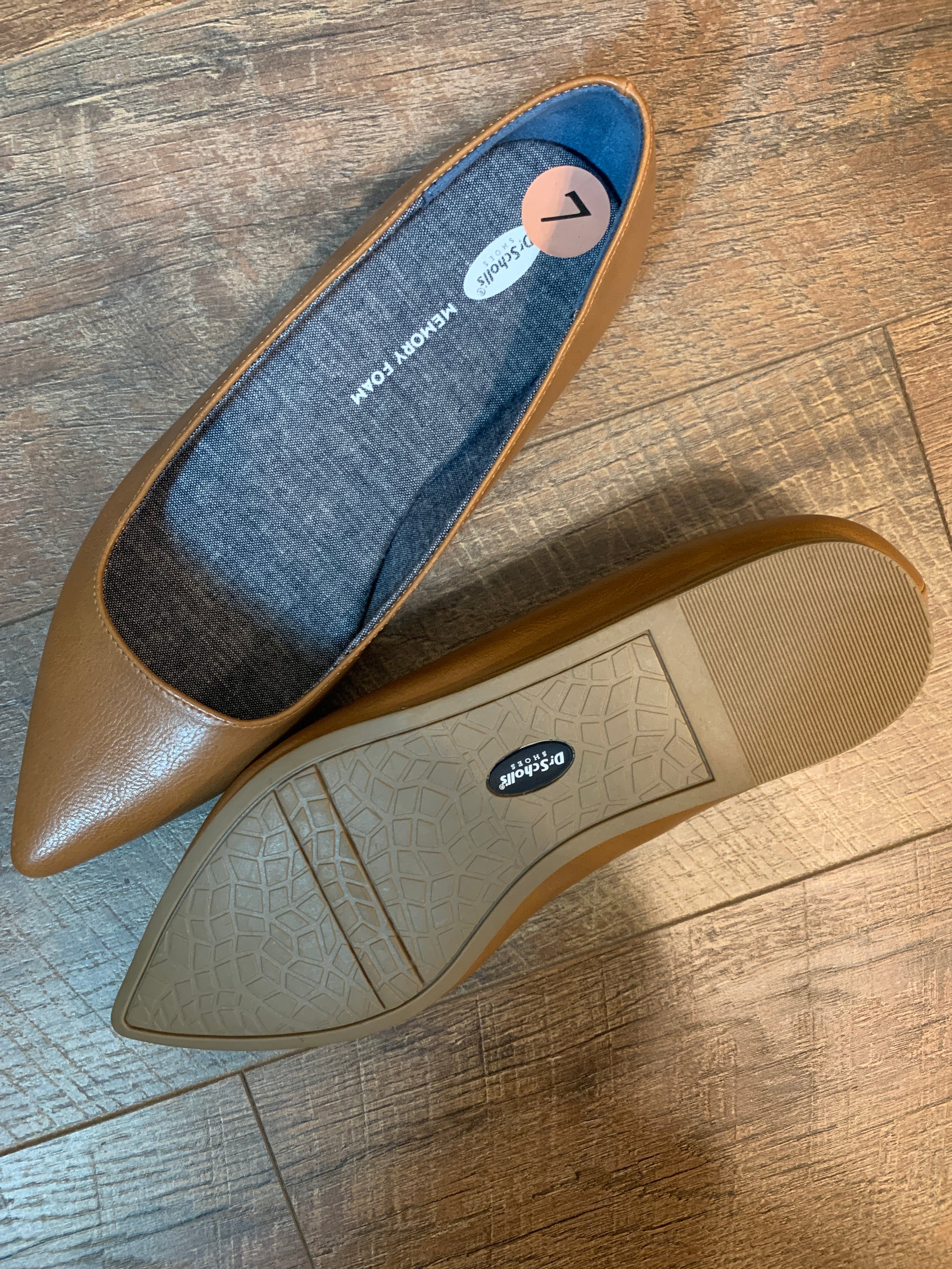 A pair of tan leather pointed-toe flats, one shown from the top and the other from the sole.  The brand name 'Dr. Scholls' is visible on the rubber outsole.